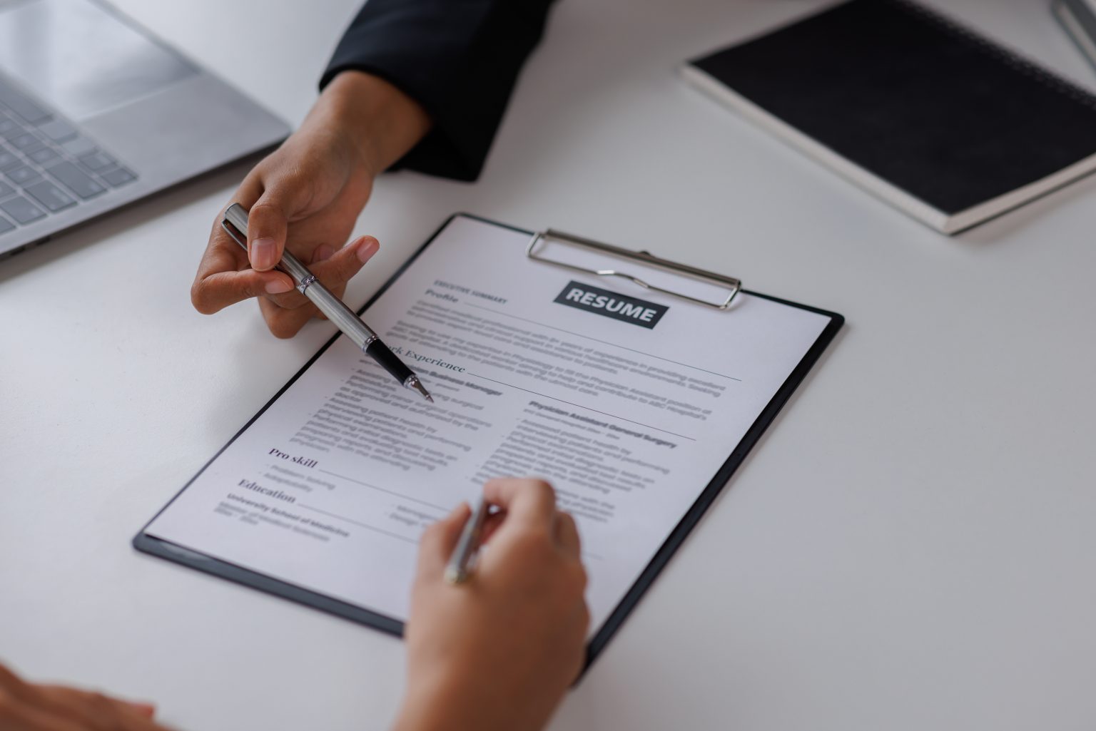 Person helping another to fill out a resume